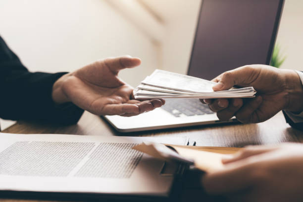 Entrepreneurs are receiving money that is a bribe of their partners with both of whom are corrupt in the company room.